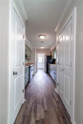 A well-appointed galley kitchen featuring hardwood flooring and ample cabinetry.