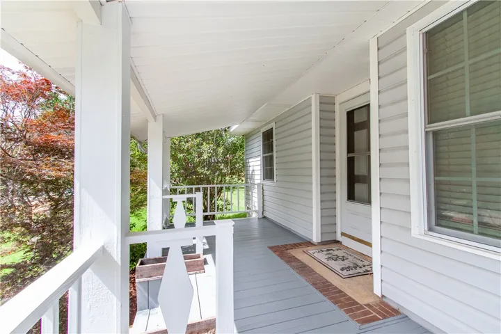 A welcoming front porch features ample space for seating and a secure entry.