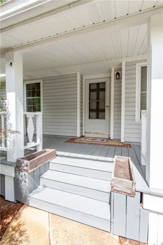 A welcoming front porch features a charming entryway with a screen door and an inviting mat.
