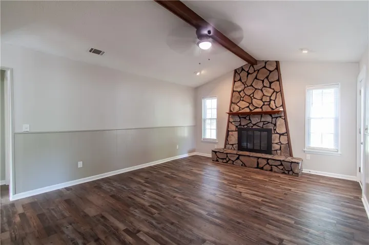 A spacious great room boasts a commanding stone fireplace and durable wood-look flooring.