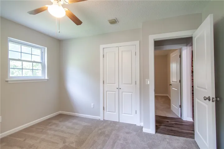 A well-lit secondary bedroom provides comfortable living with soft carpeted flooring.