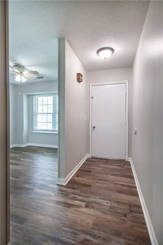 A well-lit entry with rich wood flooring leads to an inviting living space.