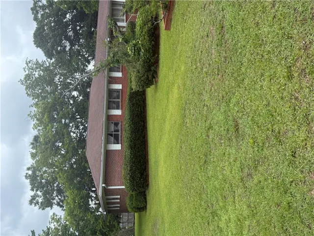 A classic brick exterior with well-maintained landscaping offers inviting curb appeal.