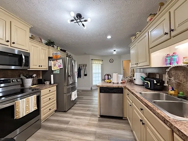 A well-equipped kitchen features ample cabinetry, stainless steel appliances, and resilient flooring.