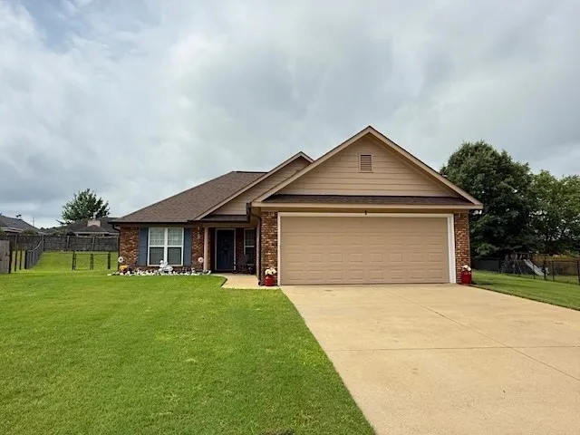 A welcoming facade with a spacious driveway and tidy lawn, inviting you home.