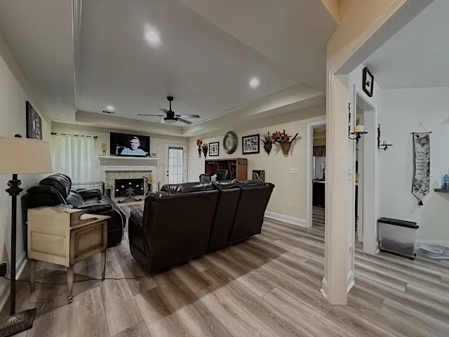 A welcoming living area features a charming fireplace and tray ceiling, creating a cozy atmosphere.