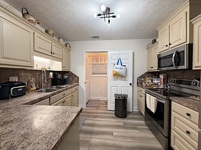 A well-equipped kitchen features a stainless steel range and microwave, complemented by ample cabinetry.
