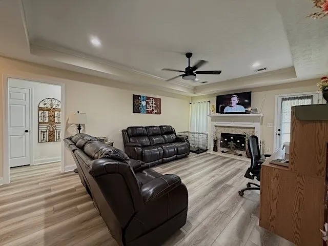 An inviting gathering space features an elegant fireplace and luminous hardwood-style flooring.