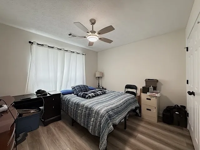 Well-lit sleeping quarters with a ceiling fan, offering a comfortable personal space.