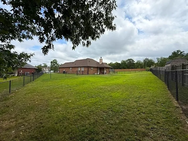 A spacious, grassy yard with secure fencing encloses this inviting property, perfect for outdoor living.