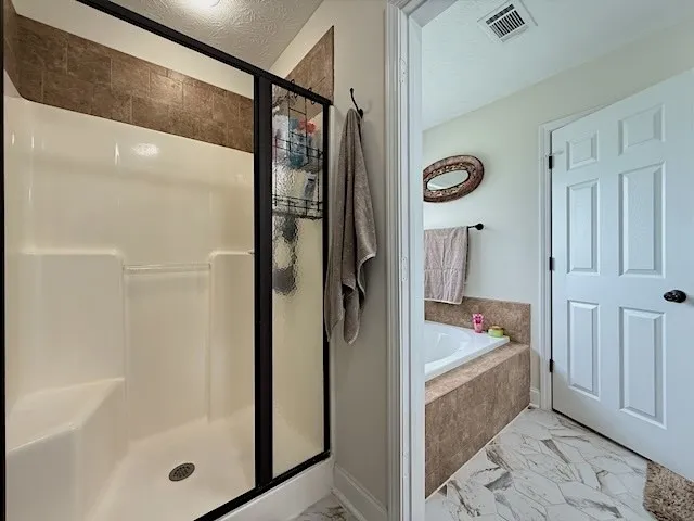 A tranquil bath with a deep soaking tub and a dedicated shower enclosure.