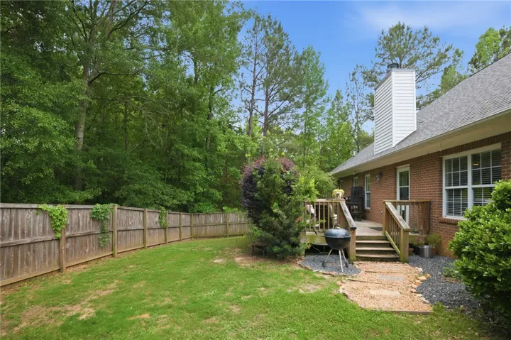 Relax on the rear deck overlooking a verdant, fenced backyard.
