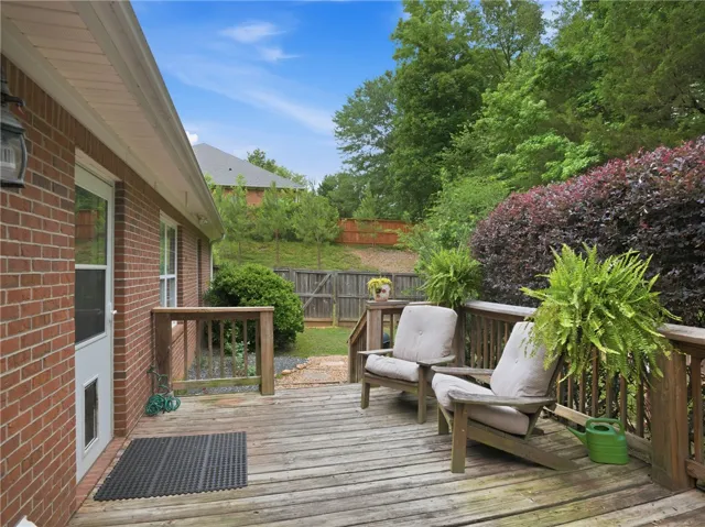 A spacious wooden deck provides a private outdoor retreat with a verdant hillside backdrop.