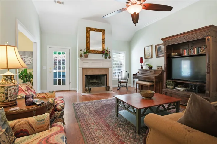 Warm hardwood floors complement a fireplace, perfect for cozy gatherings in this inviting living space.