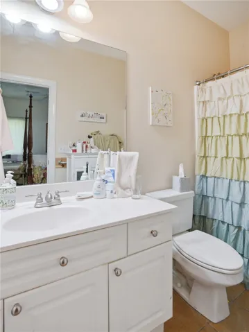 A well-appointed bathroom features a crisp white vanity and a practical tiled floor.