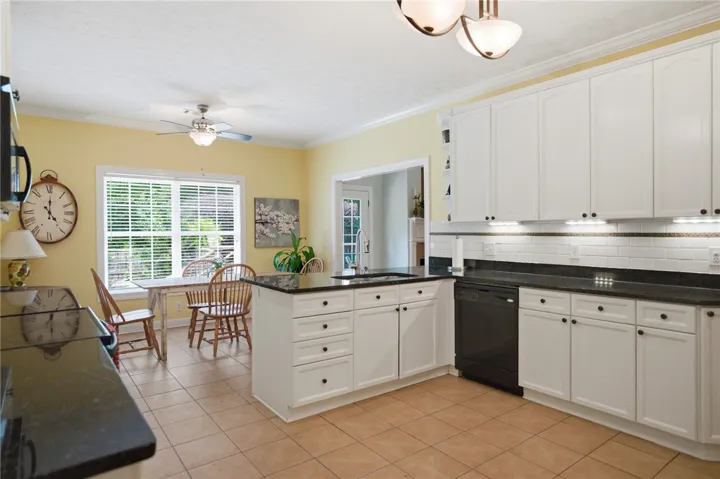 A warm, inviting kitchen presents ample cabinetry and an adjacent sun-filled breakfast area.