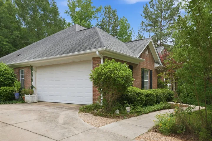 A classic brick exterior blends seamlessly with lush, established landscaping.