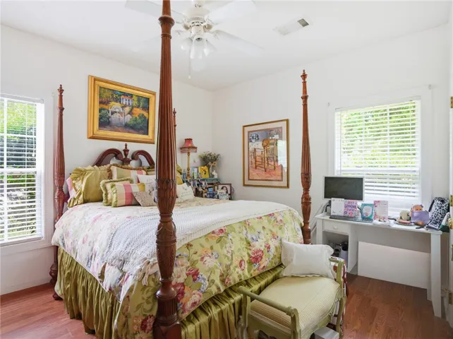 Hardwood floors and a detailed four-poster bed create a warm, inviting personal retreat.