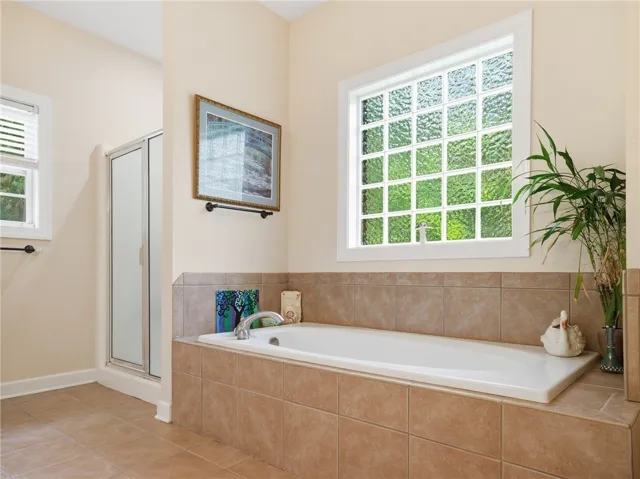 Indulge in a tranquil bathing experience with this deep soaking tub and tiled shower.