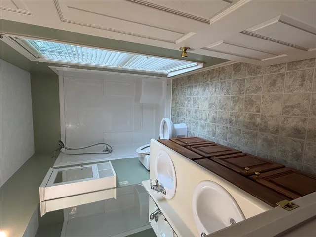 Functional primary bathroom features a shower, dual sinks, and ample storage.