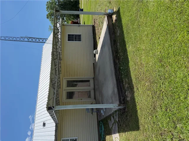 A well-maintained side yard with a concrete patio offers a functional outdoor space.