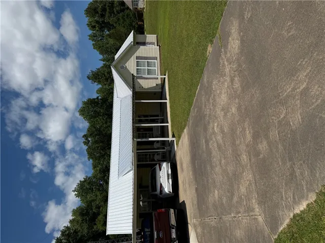 A well-maintained facade with a long covered carport provides ample parking.