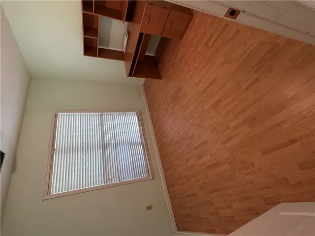 A versatile room featuring durable wood flooring and natural light, perfect for an office or additional living space.