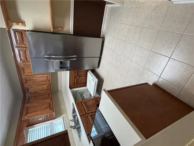 A well-appointed kitchen features ample wood cabinetry, stainless steel appliances.