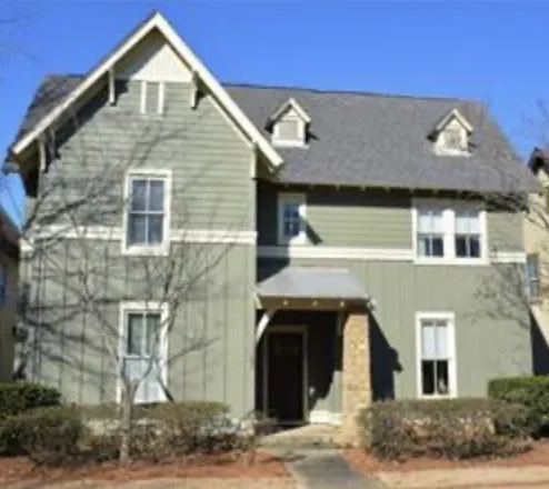 A welcoming facade with dormer windows and a covered entrance defines this charming home.