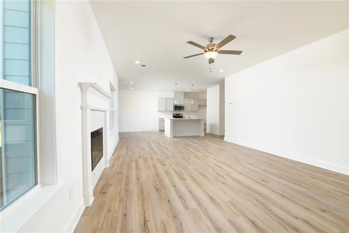 A spacious open-plan living area flows directly into the kitchen with wood flooring throughout.