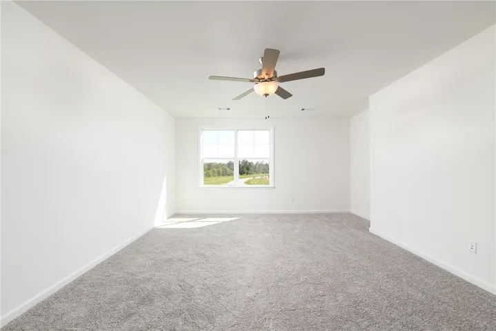 Plush carpeting and a multi-pane window define this versatile secondary room.