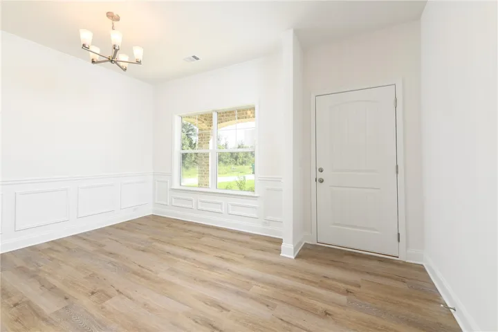 Elegant wainscoting and warm wood flooring define this versatile entry dining room.