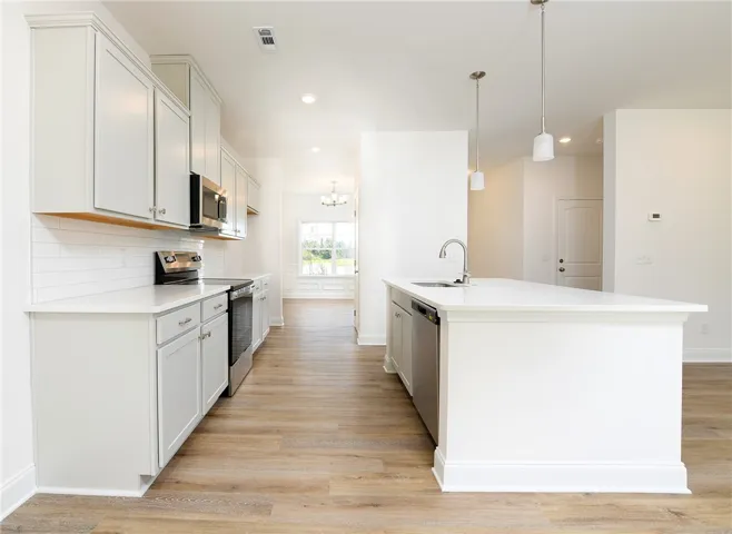 Gleaming stone counters and warm wood floors define this open culinary space.