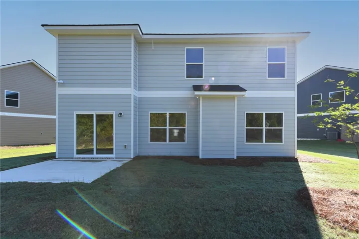A concrete patio extends from the back of this two-story home onto the lawn.