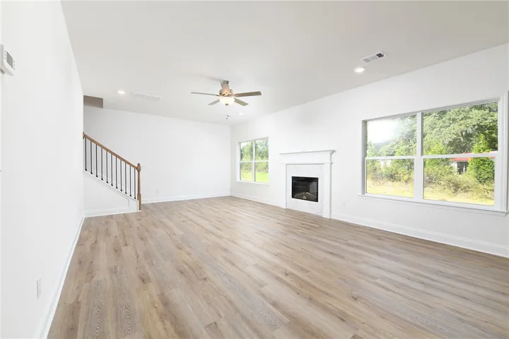 An open living space features wood-finish floors, a modern fireplace, and large windows.