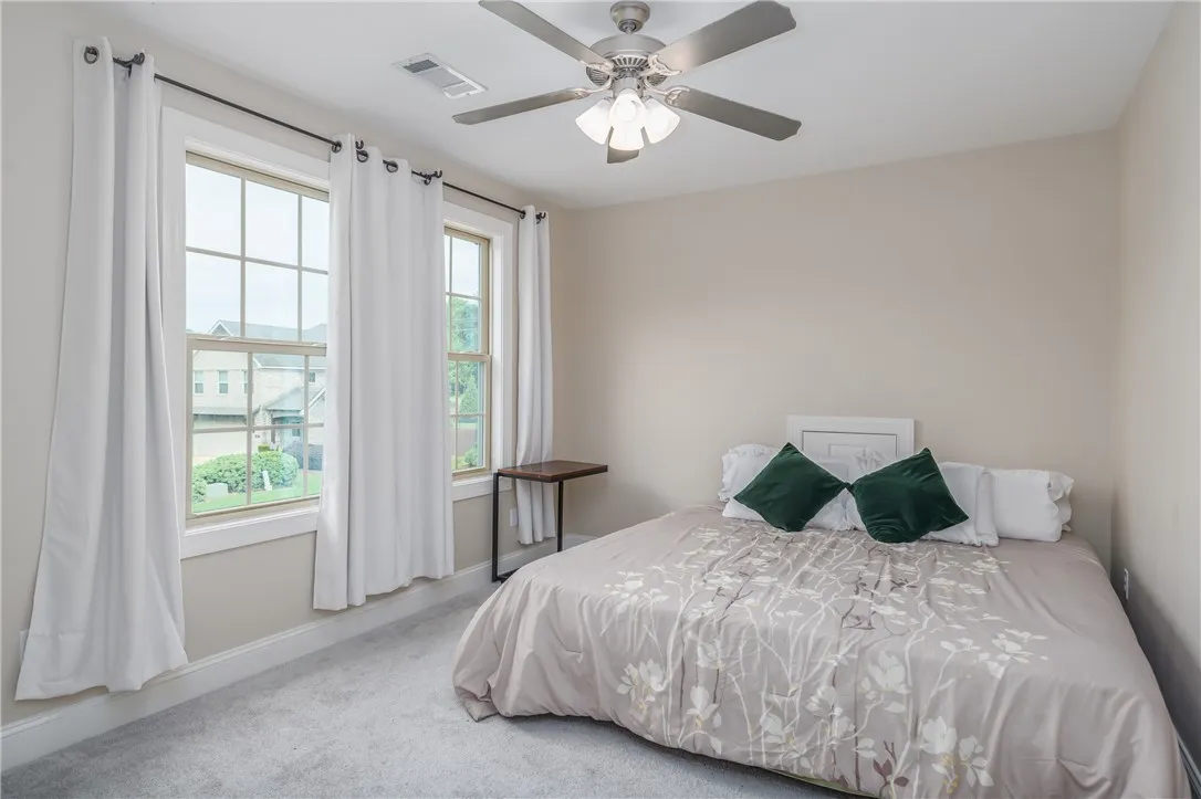 Natural light floods this inviting room through large windows, creating a peaceful and comfortable ambiance.