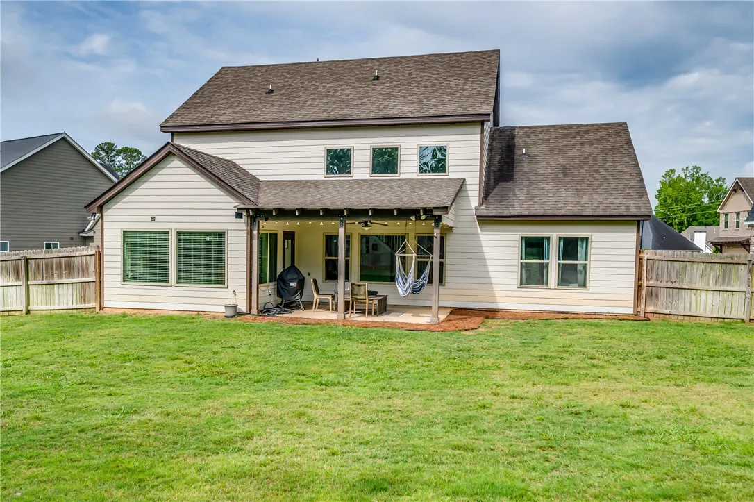A spacious backyard with a covered patio provides ample room for outdoor activities and relaxation.