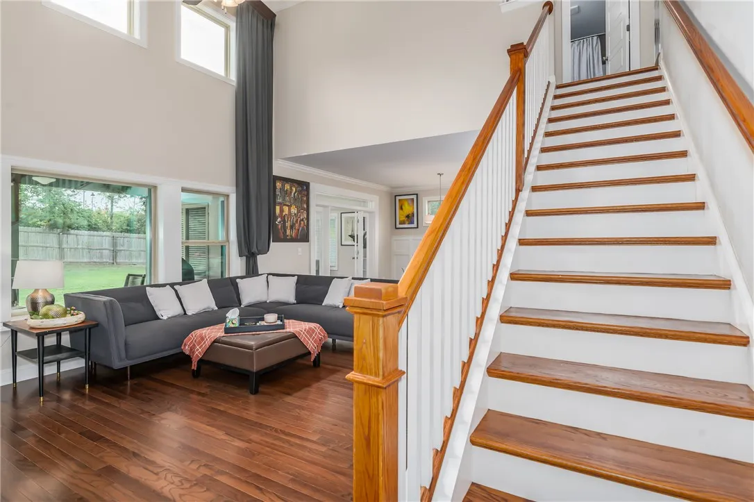 Hardwood flooring extends throughout the inviting living area, complemented by a striking staircase.
