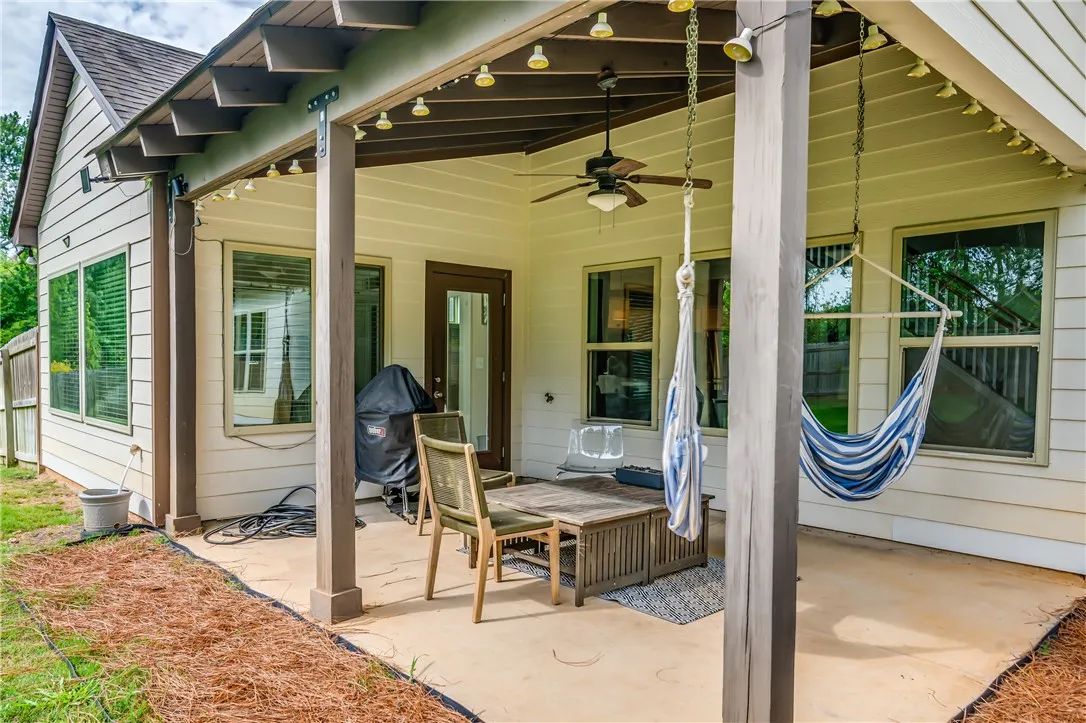 A spacious concrete patio offers outdoor relaxation with hammocks and ample seating.