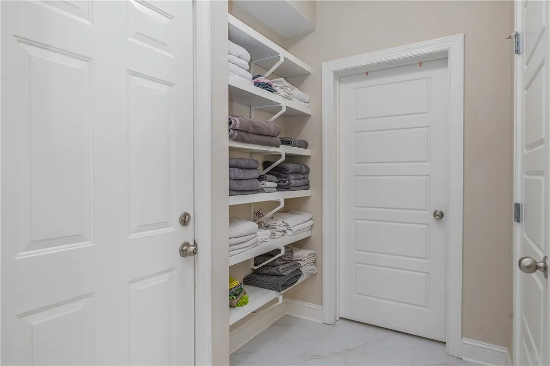 Organized linen storage and multiple panel doors enhance this functional utility area.