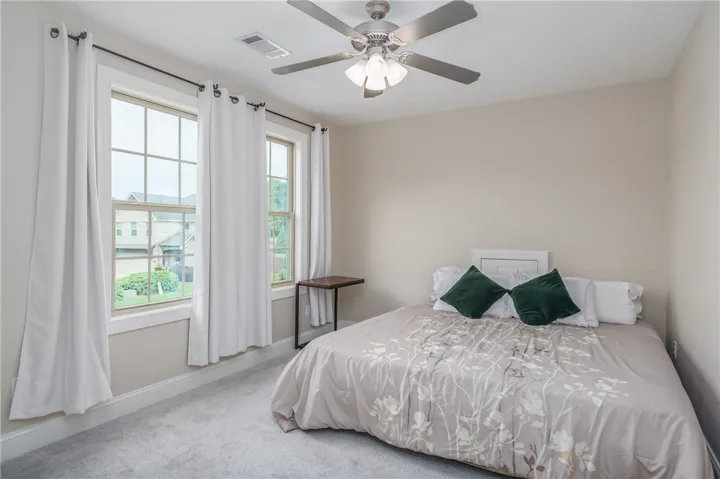 Natural light floods this inviting room through large windows, creating a peaceful and comfortable ambiance.