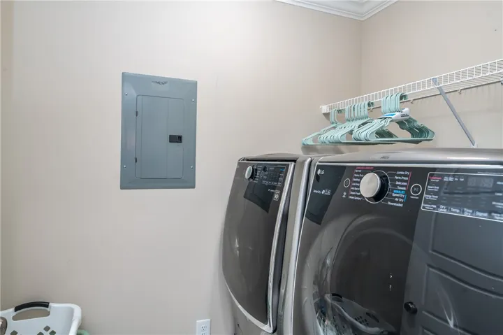 Laundry day made simple with a functional washer and dryer set, complemented by convenient overhead shelving.