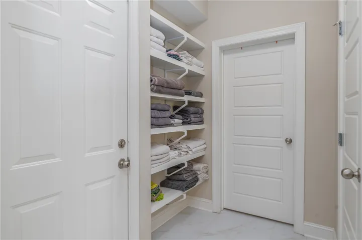 Organized linen storage and multiple panel doors enhance this functional utility area.