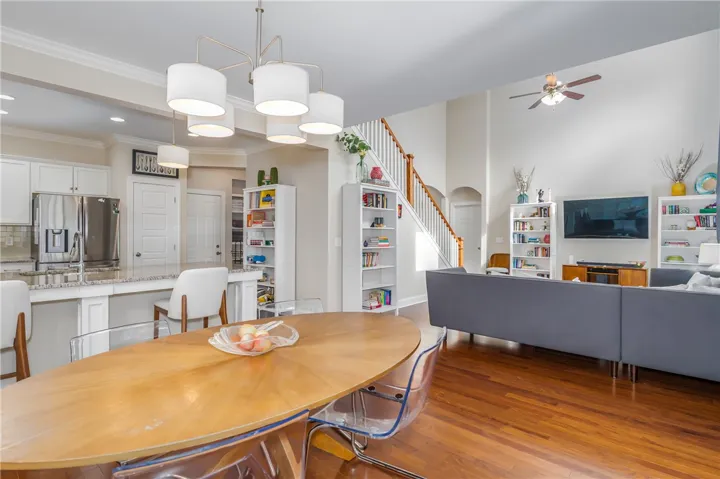 Hardwood floors and soaring ceilings characterize this inviting open-concept living area.