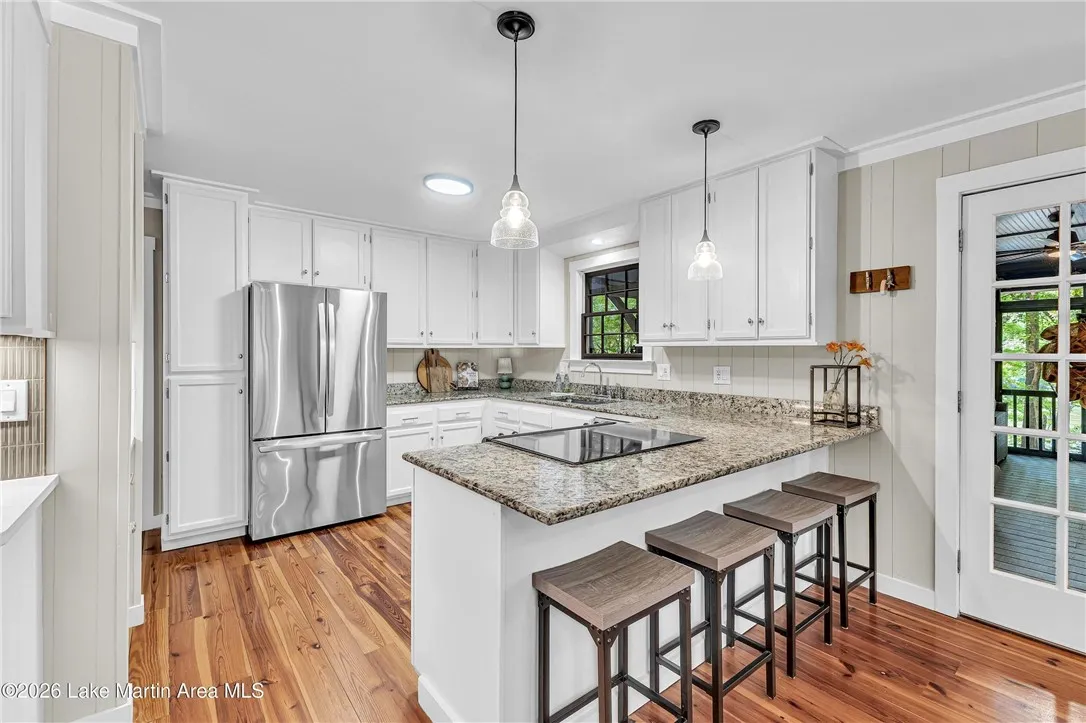 A well-lit culinary space showcases durable hardwood floors and modern stainless steel appliances.