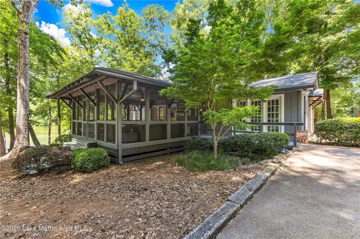 Lakeside living beckons from this charming residence featuring an inviting screened porch.
