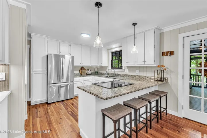 A well-lit culinary space showcases durable hardwood floors and modern stainless steel appliances.