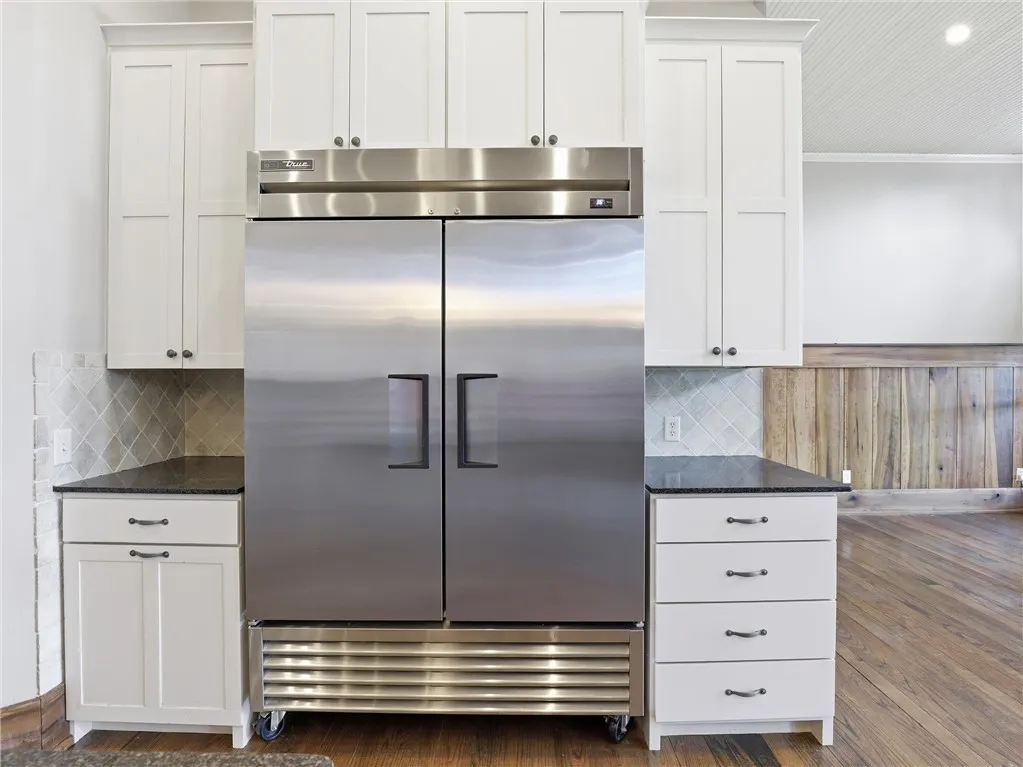 Culinary aspirations meet industrial design with this dual-door stainless steel refrigerator, framed by classic white cabinetry.