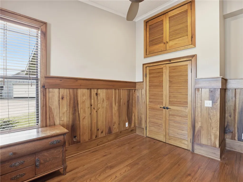 Rich hardwood flooring and paneling create a welcoming ambiance in this inviting space.