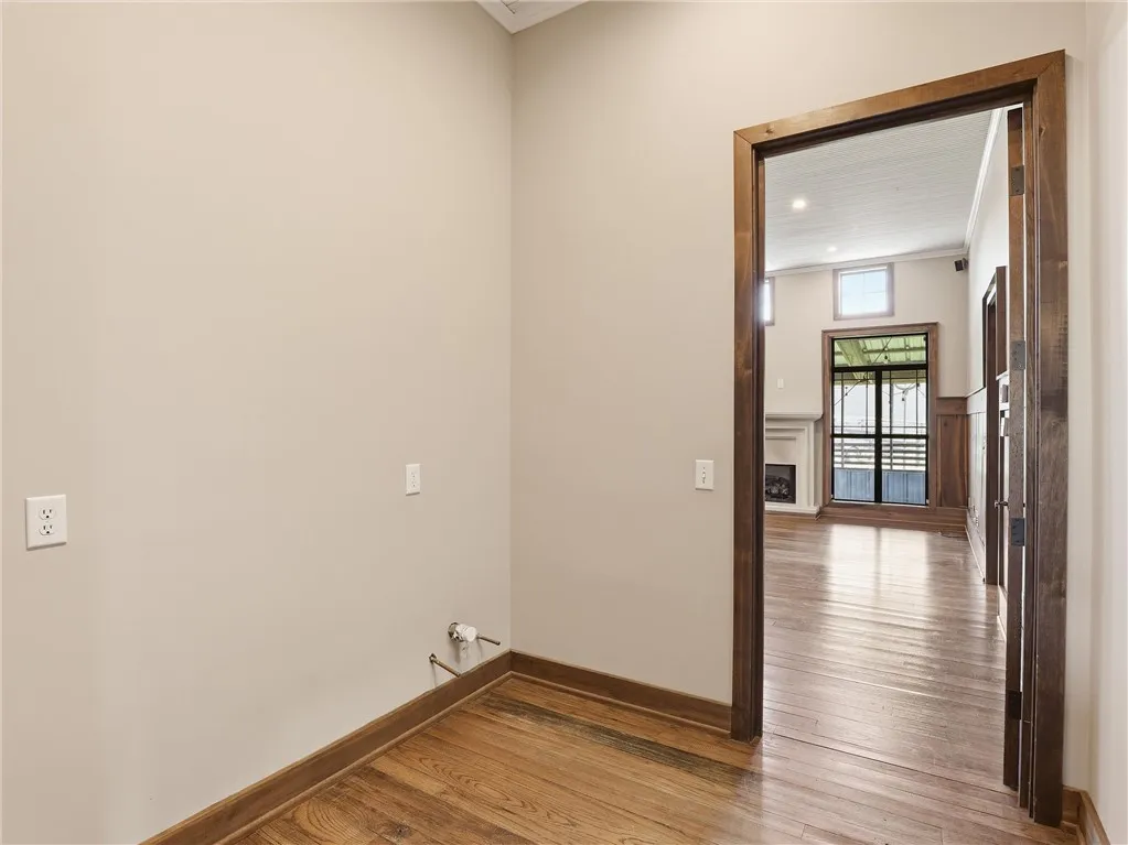 Rich hardwood flooring leads to a bright living area, offering a glimpse of the home's inviting interior.